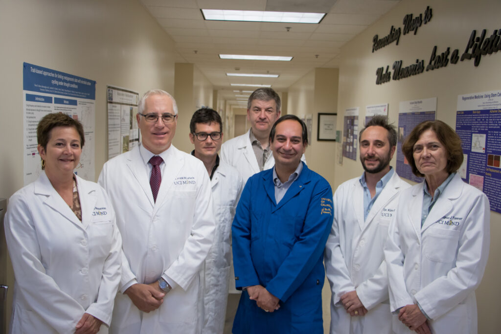 Alzheimer's Disease researchers smiling in a hall with Dean LaFerla and others.